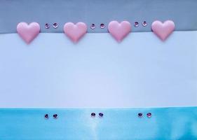 Template. Satin ribbons in blue and gray with pink hearts and sequins on a white background with a place for the inscription. photo
