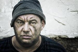 Portrait of a homeless man in a knitted hat. Look at the camera. photo