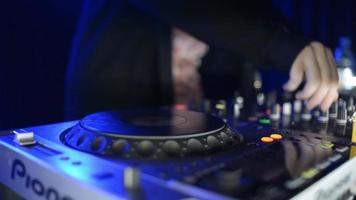 Hände von DJ-Tweak-Steuerelementen auf dem Plattendeck im Nachtclub. Plattenspieler, Mixer, Teller video