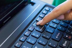 Dedo presionando el botón Eliminar en un teclado de computadora foto