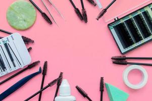 Template. Tools for eyelash extension on a pink background with a place for writing. photo