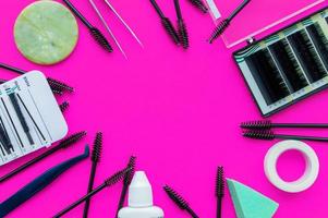 Template. Tools for eyelash extension on a pink background with a place for writing. photo
