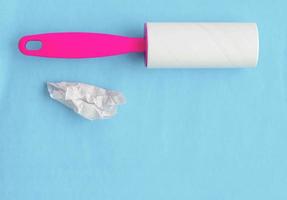 Glue roller for cleaning clothes from wool and animal hair on a blue background with a place for writing. photo