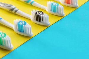 Cepillos de dientes multicolores sobre un fondo azul y amarillo. de cerca. foto