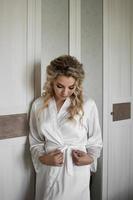 the bride in a silk robe stands at the mirror. preparation for the wedding ceremony. selective focus. film grain. photo