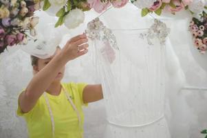 una costurera en un salón de bodas está preparando un vestido para la venta. vestido de novia con arco de jardín