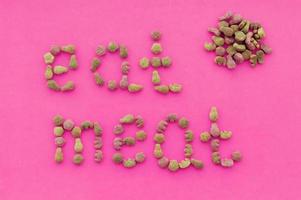 The inscription eat meat from pieces of food on a pink background. The view from the top photo