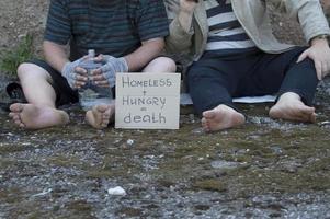 dos vagabundos se sientan en la calle y mendigan. pobreza, desempleo, alcoholismo. foto