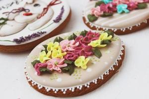 Easter colored gingerbread in the shape of an egg with a rabbit and flowers drawn on them. photo