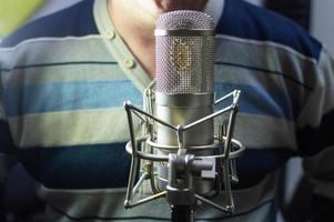 A man at a microphone in a recording Studio. Musical creativity. photo