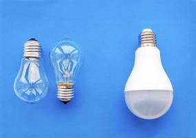 Energy-saving lamp with incandescent lamps in a row on a blue background. The concept of saving energy. photo
