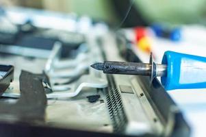 a man repairs a computer, solders a board, repairs electronics and modern technologies photo