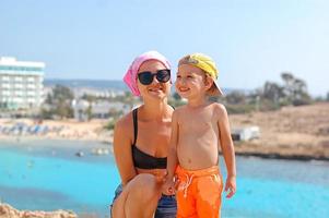 madre e hijo en la playa en un día soleado. turismo, viajes, vacaciones en familia. foto