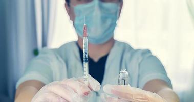 a woman in a white coat with a syringe in hand photo