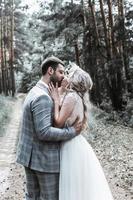 the bride and groom kiss in the forest at the wedding ceremony. selective focus. film grain. photo