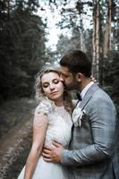 the bride and groom kiss in the forest at the wedding ceremony. selective focus. film grain.