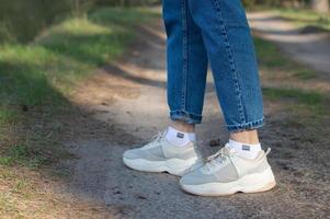 female legs in white sneakers photo