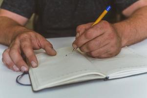 a person makes an entry in a notebook for doing business photo