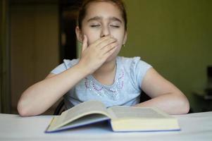 child reading a book at the table photo