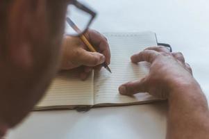 a person makes an entry in a notebook for doing business photo