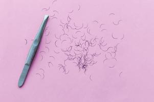 tweezers for plucking eyebrows and hair on a pink background with a place for writing photo