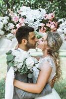 la novia y el novio se besan en el bosque en la ceremonia de la boda. enfoque selectivo. grano de la película. foto