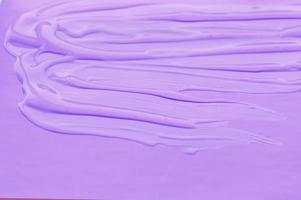 The texture of the transparent gel is smeared on a lilac background. photo