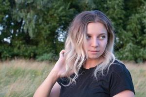 portrait of a beautiful European girl with loose hair against the background of nature photo