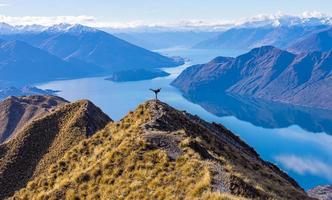 Asian tourist practicing martial arts side leg kick at Roy's Peak Lake Wanaka New Zealand photo