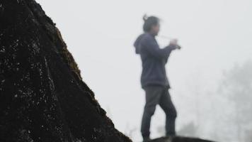 A hiker photographer taking pictures of morning landscape in winter mountains video