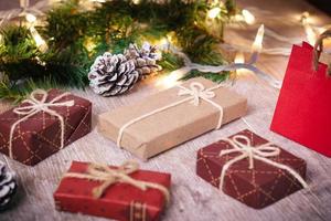 mini regalos de navidad sobre fondo de madera con tonos cálidos y fríos