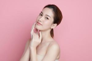 hermosa joven asiática con piel limpia y fresca sobre fondo rosa, cuidado facial, tratamiento facial, cosmetología, belleza y spa, retrato de mujeres asiáticas. foto