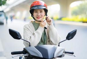 Asian woman driving a motorbike on her way to work photo