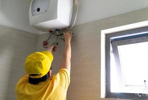 Repairmen are repairing and cleaning water heaters periodically photo