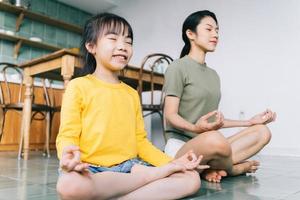 Mother and daughter doing yoga at home photo