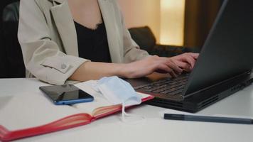 mujer trabajadora usuaria que usa escribir en el teclado de la computadora portátil sentarse en la oficina en casa. video