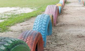 Neumáticos viejos con pintura colorida en un patio de recreo, enfoque selectivo foto
