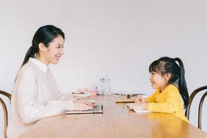 Mother and daughter studying at home photo