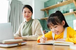 Asian Mother and daughter studying together at home photo