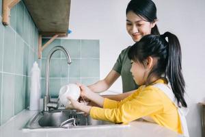 Mother and daughter wash the dishes together. photo