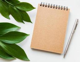 Craft notebook and green leaves photo