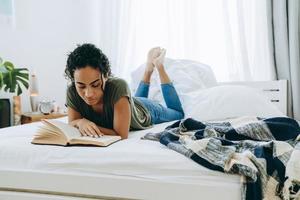 Concentrated African woman reading book photo