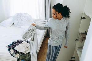 African tired woman pulls things out of the closet photo