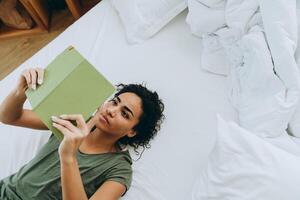 Overhead view of concentrated African woman reading something from notepad photo