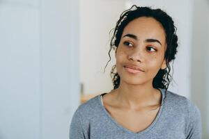 Black woman smiling and looking aside during spending time at home photo