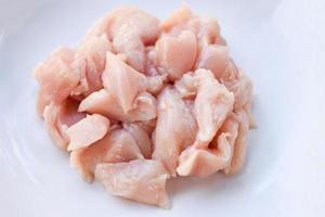 Pieces of raw chicken meat fresh raw cut chicken fillet on white plate background photo