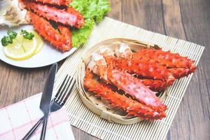 Alaskan King Crab Legs cooked seafood with lemon spices on white plate in the wooden table - red crab hokkaido photo