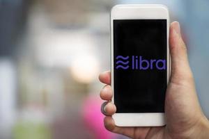 Libra coin logo on smartphone New project libra a cryptocurrency launched by Facebook looks to mainstream digital currency through apps like photo