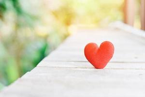 Tarjeta de vacaciones día de San Valentín corazón rojo sobre madera vieja con puesta de sol para el concepto de filantropía - corazones sobre un fondo de madera donar ayudar a dar amor cuidar foto