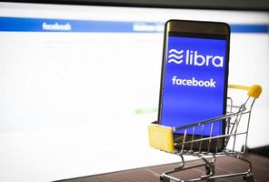 Libra coin blockchain concepto con smartphone en carrito de compras nuevo proyecto libra una criptomoneda lanzada por facebook parece a la moneda digital convencional foto